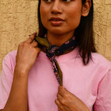 Petit foulard Antigone Nuit noué au cou, mains sur le foulard