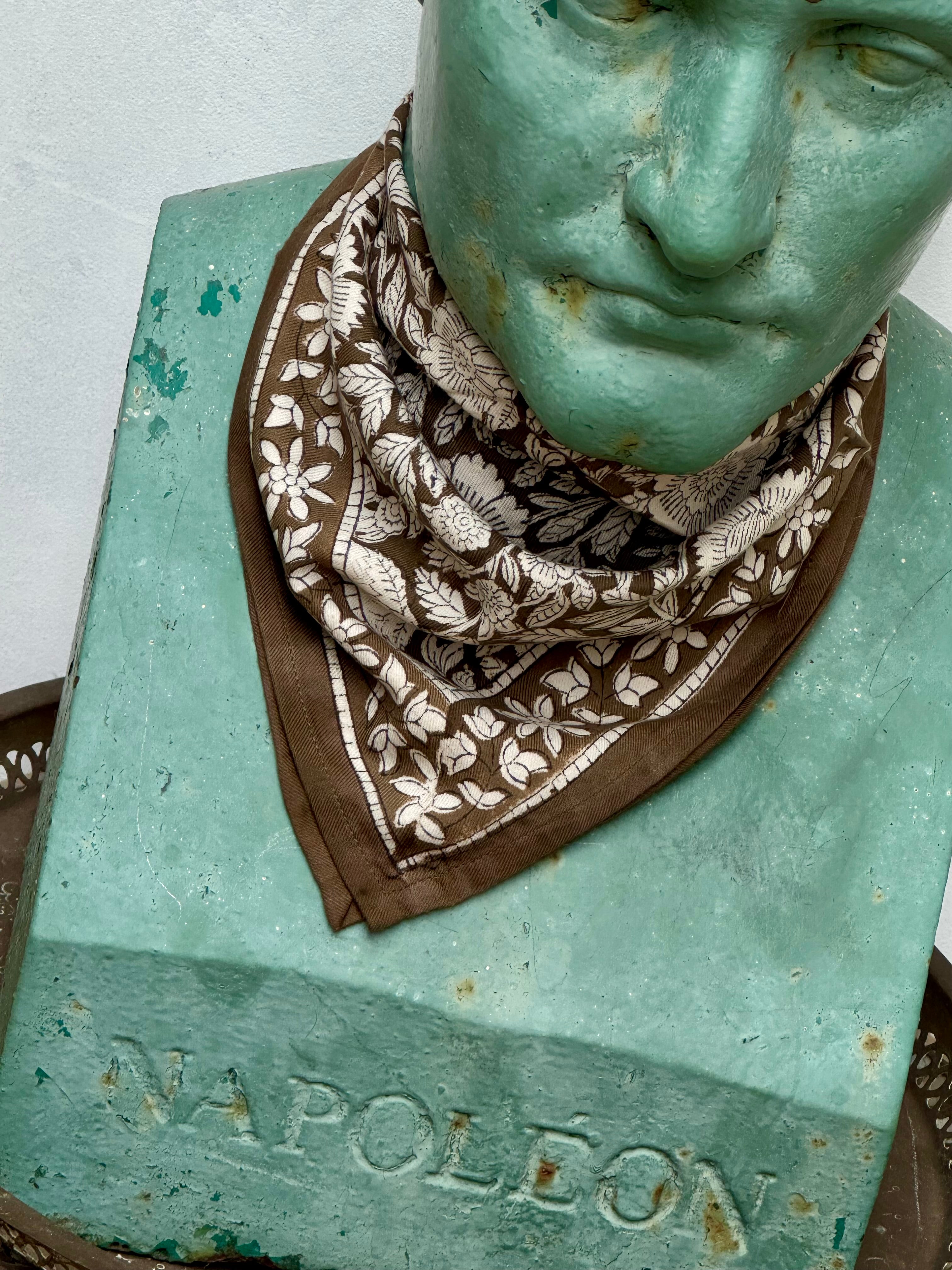 petit foulard fleuri kaki et écru porté en point par une statue