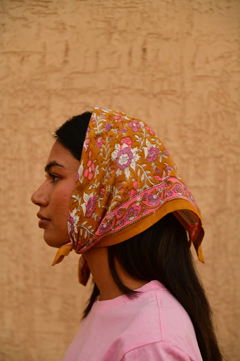 Petit foulard Calypso Caramel porté en fichu sur la tête, vue de trois quarts