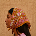 Petit foulard Calypso Caramel porté en fichu sur la tête, vue de trois quarts