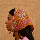 Petit foulard Calypso Caramel porté en fichu sur la tête, vue de trois quarts