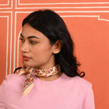 Petit foulard Calypso Flame noué au cou, porté avec un tee-shirt rose