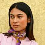 Petit foulard Carthage Violet noué au cou, porté avec un tee-shirt rose