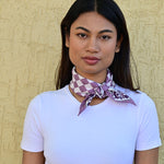 petit foulard écru et violet roulé et noué autour du cou d'une jeune femme - byzantine