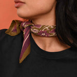Petit foulard Hélios Kaki de byzantine noué au cou, motif olive et violet, avec un tee-shirt noir