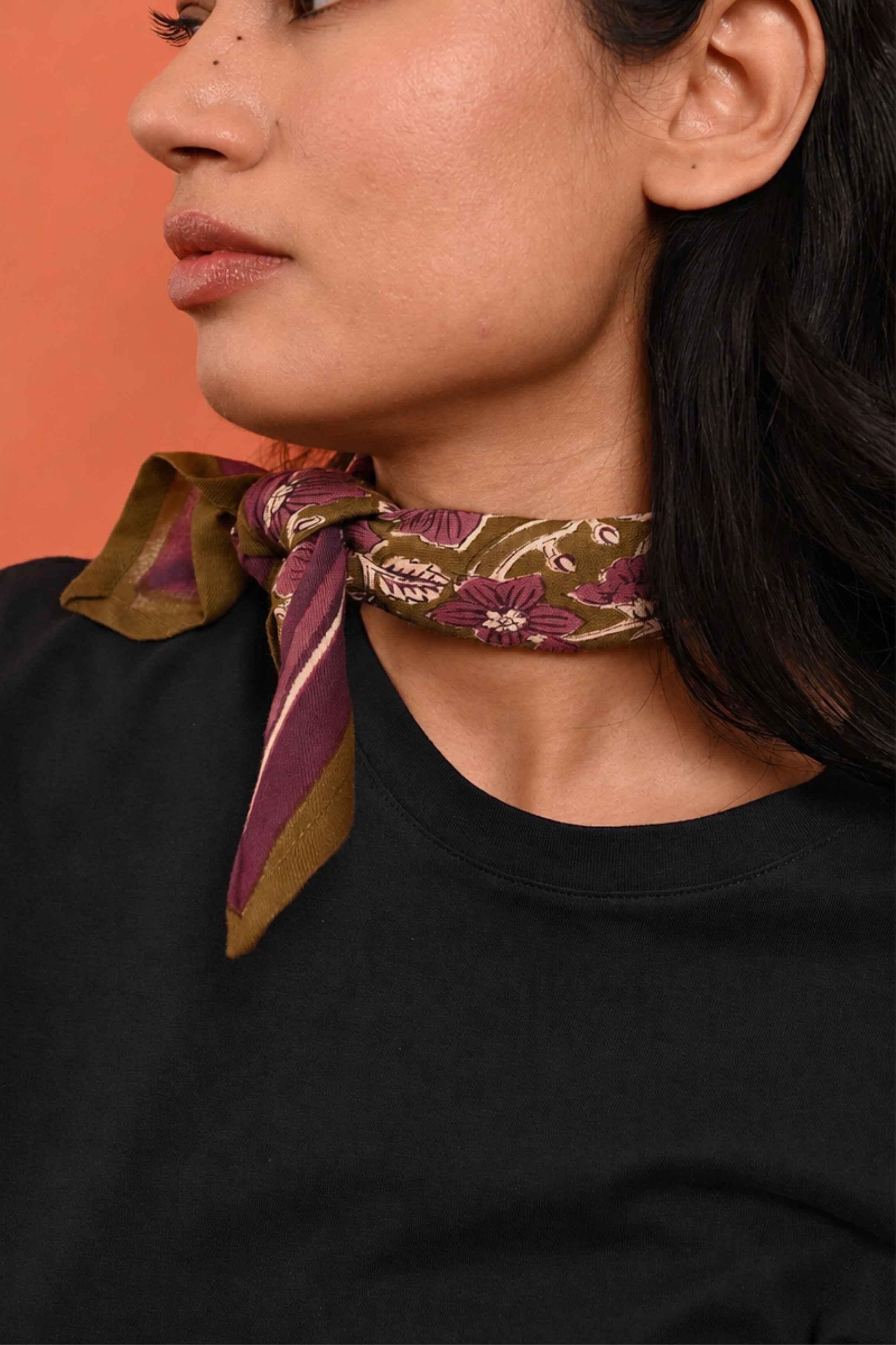 Petit foulard Hélios Kaki de byzantine noué au cou, motif olive et violet, avec un tee-shirt noir
