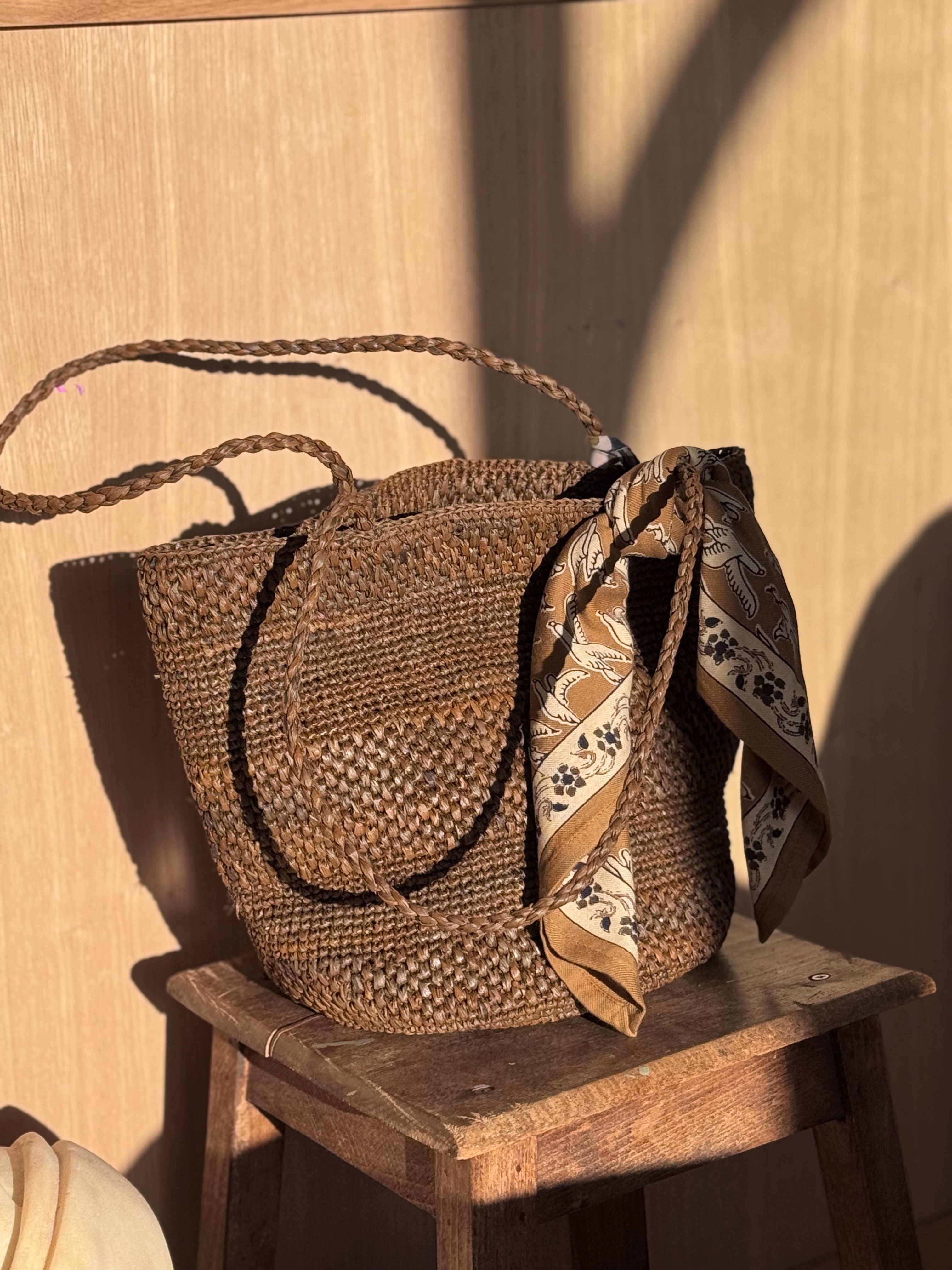 Petit foulard Mercure Bistre noué à l'anse d'un panier tressé