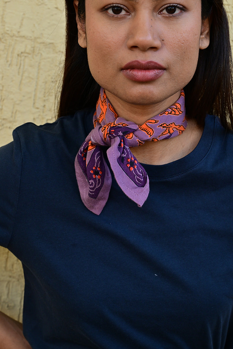 Petit foulard violet et orange vif roulé et noué autour du cou d’une jeune femme indienne
