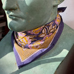Petit foulard N°113 Bleu de byzantine, fleurs violettes et bordure moutarde, noué au cou d'un buste