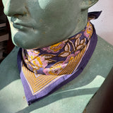 Petit foulard N°113 Bleu de byzantine, fleurs violettes et bordure moutarde, noué au cou d'un buste