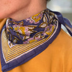 Gros plan sur le petit foulard N°113 Bleu de byzantine noué au cou, tee-shirt moutarde