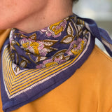 Gros plan sur le petit foulard N°113 Bleu de byzantine noué au cou, tee-shirt moutarde