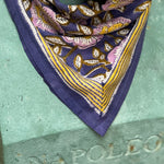 Gros plan sur le petit foulard N°113 Bleu porté par un buste, bordure moutarde