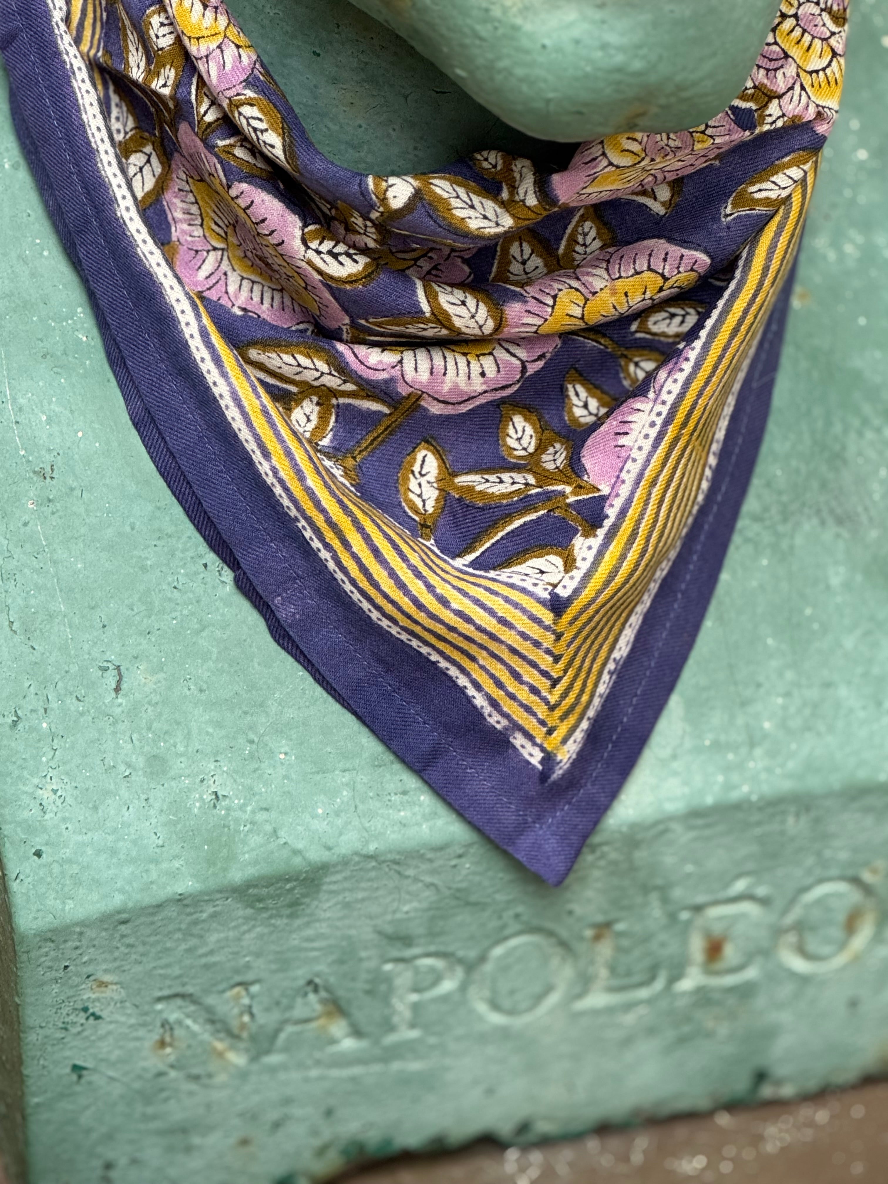 Gros plan sur le petit foulard N°113 Bleu porté par un buste, bordure moutarde