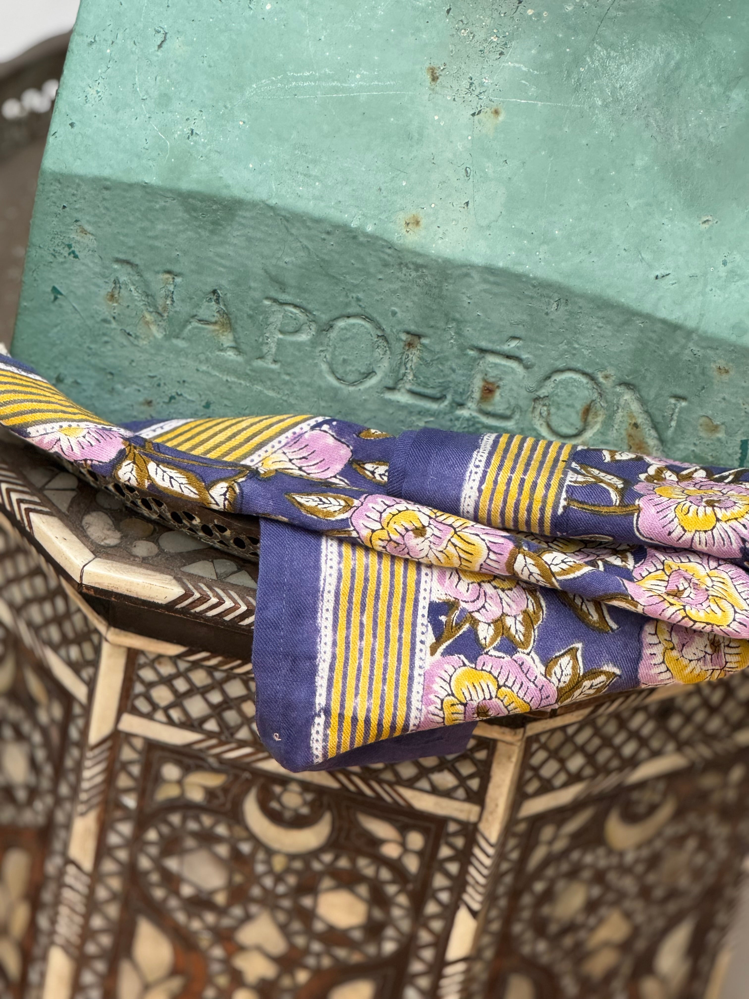 Petit foulard N°113 Bleu posé sur un buste et une table marquetée