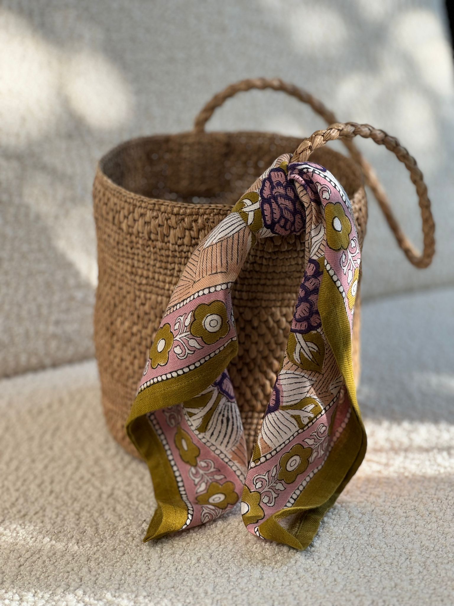 petit foulard penelope myrtille de byzantine, imprimé fleuri vert, attaché à un sac main