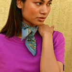 Petit foulard Séléné Bleu horizon noué au cou, main sur l'épaule