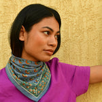Petit foulard Séléné Bleu horizon noué au cou, vue de profil, tee-shirt violet