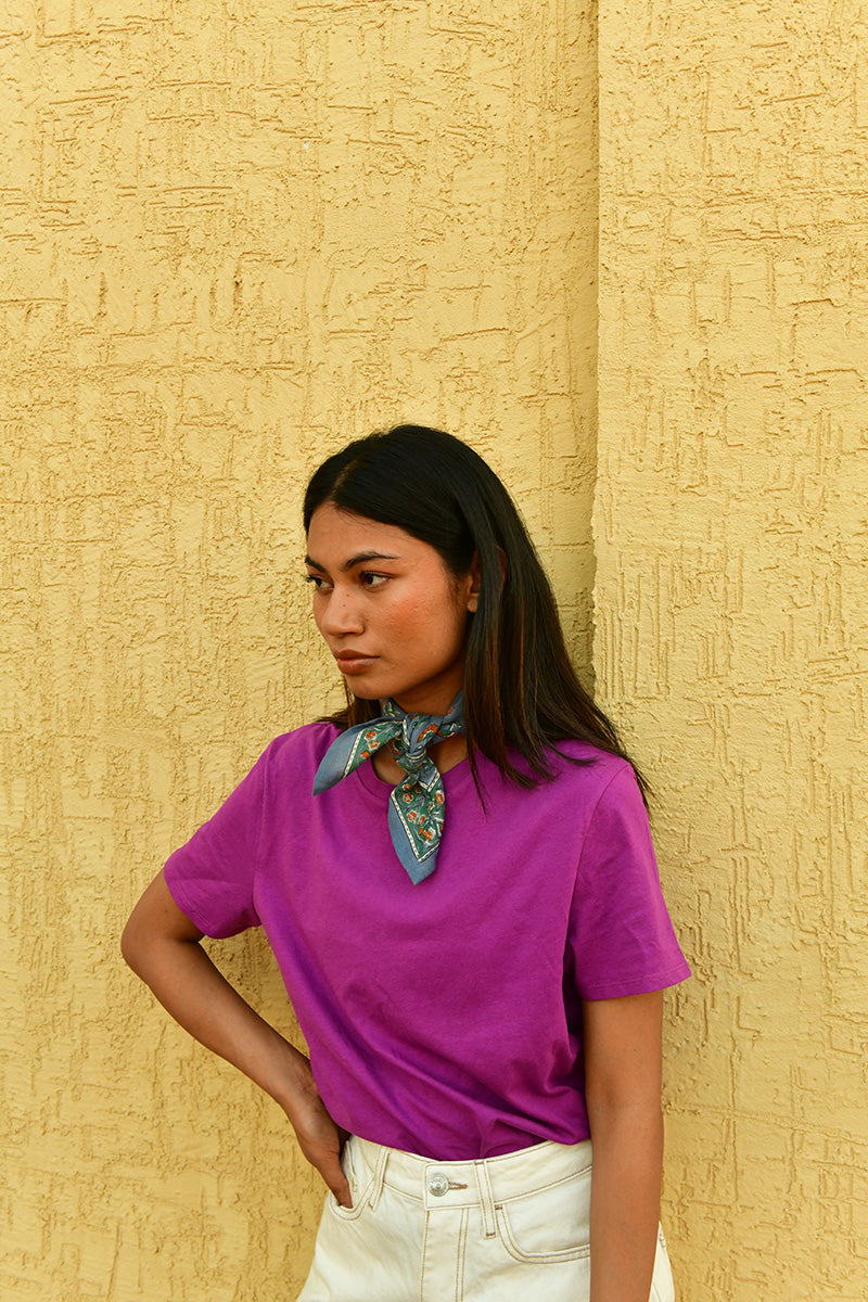 Petit foulard Séléné Bleu horizon noué au cou, main sur la hanche