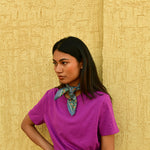 Petit foulard Séléné Bleu horizon noué au cou, main sur la hanche