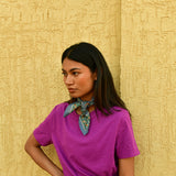 Petit foulard Séléné Bleu horizon noué au cou, main sur la hanche