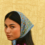 Petit foulard Séléné Bleu horizon porté en fichu sur la tête, vue de profil