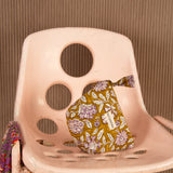 Petite trousse beauté Carthage Kaki à nœud posée sur une chaise rose