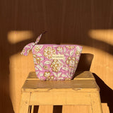 Petite trousse beauté Carthage Lilas à nœud posée sur un tabouret en bois