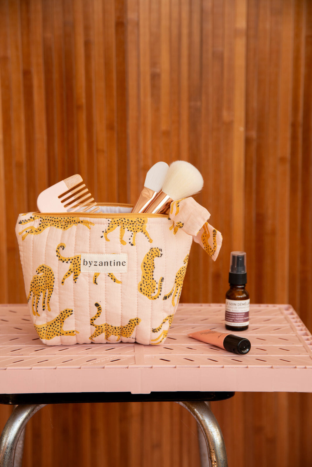 Gros plan sur la petite trousse beauté Fauve Rose de Byzantine, pinceaux et peigne