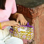 Petite trousse de toilette Carthage Kaki ouverte par une femme assise