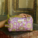 Petite trousse de toilette Carthage Lilas, fleurs écrues sur fond lilas, sur un muret