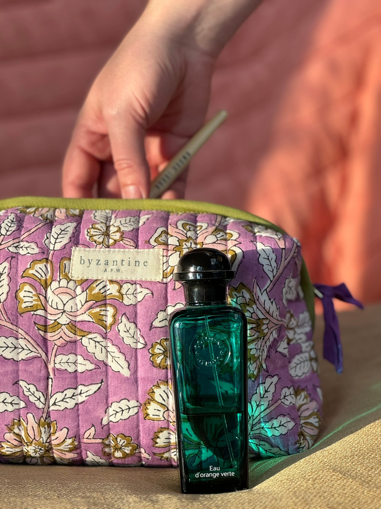 Petite trousse de toilette Carthage Lilas ouverte, avec un flacon de parfum vert