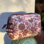 Trousse de toilette Carthage Prune posée sur un buste en plâtre