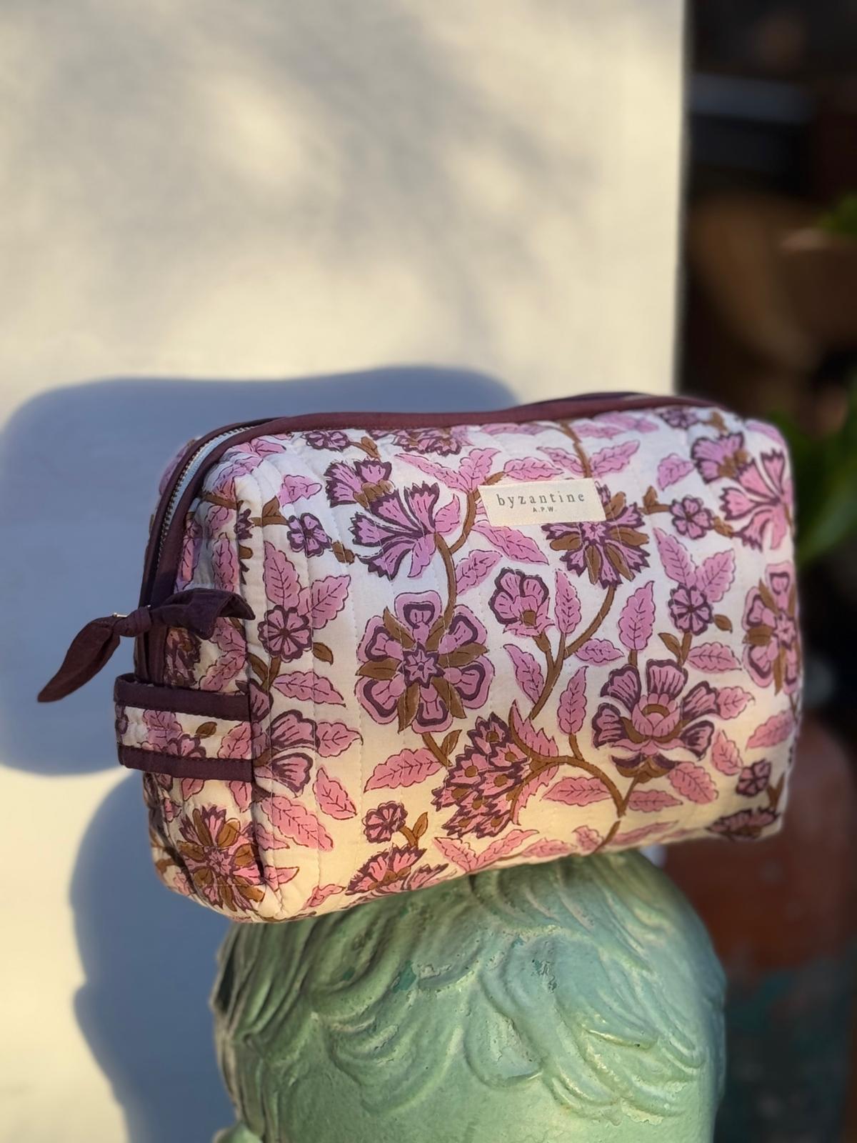 Trousse de toilette Carthage Prune posée sur un buste en plâtre