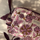Gros plan sur le motif fleuri et le nœud de la trousse Carthage Prune