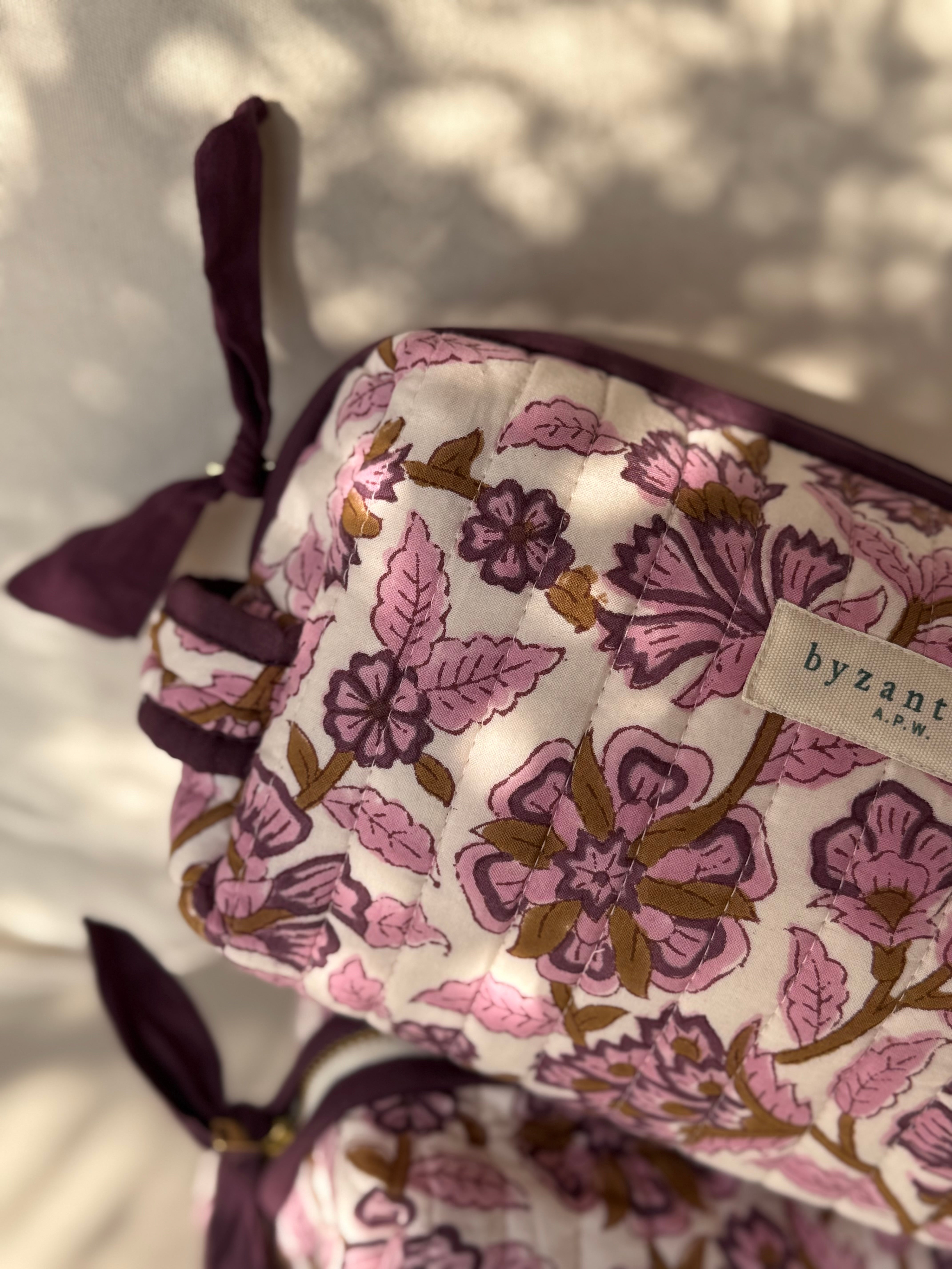 Gros plan sur le motif fleuri et le nœud de la trousse Carthage Prune