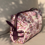 Trousse de toilette Carthage Prune à nœud, vue de côté sur un canapé