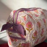 Petite trousse de toilette Éphèse Rose posée sur un velours rouge