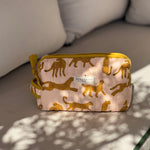 Petite trousse de toilette Fauve Rose de byzantine, guépards ocre sur fond rose, sur un banc
