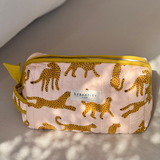 Petite trousse de toilette Fauve Rose posée sur un banc au soleil