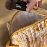 Pinceaux de maquillage sortant de la petite trousse de toilette Fauve Rose
