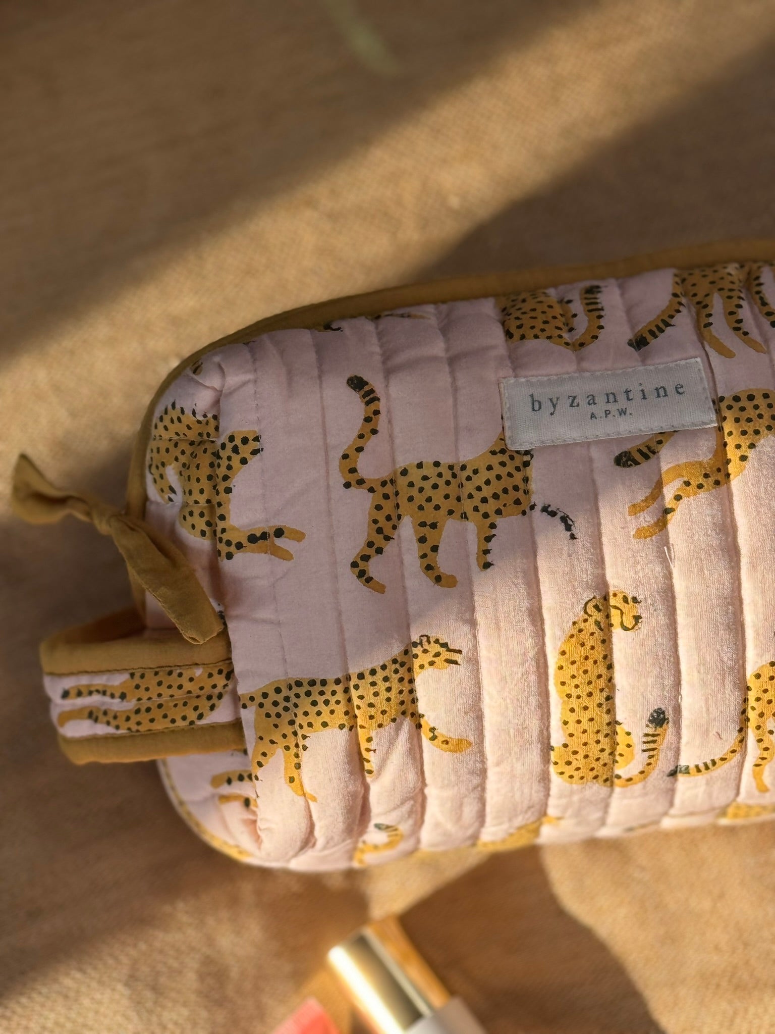 Gros plan sur la petite trousse de toilette Fauve Rose et son étiquette