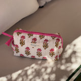 Petite trousse de toilette N°50 Rose fermée, posée sur un banc