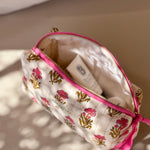 Petite trousse de toilette N°50 Rose ouverte sur un banc