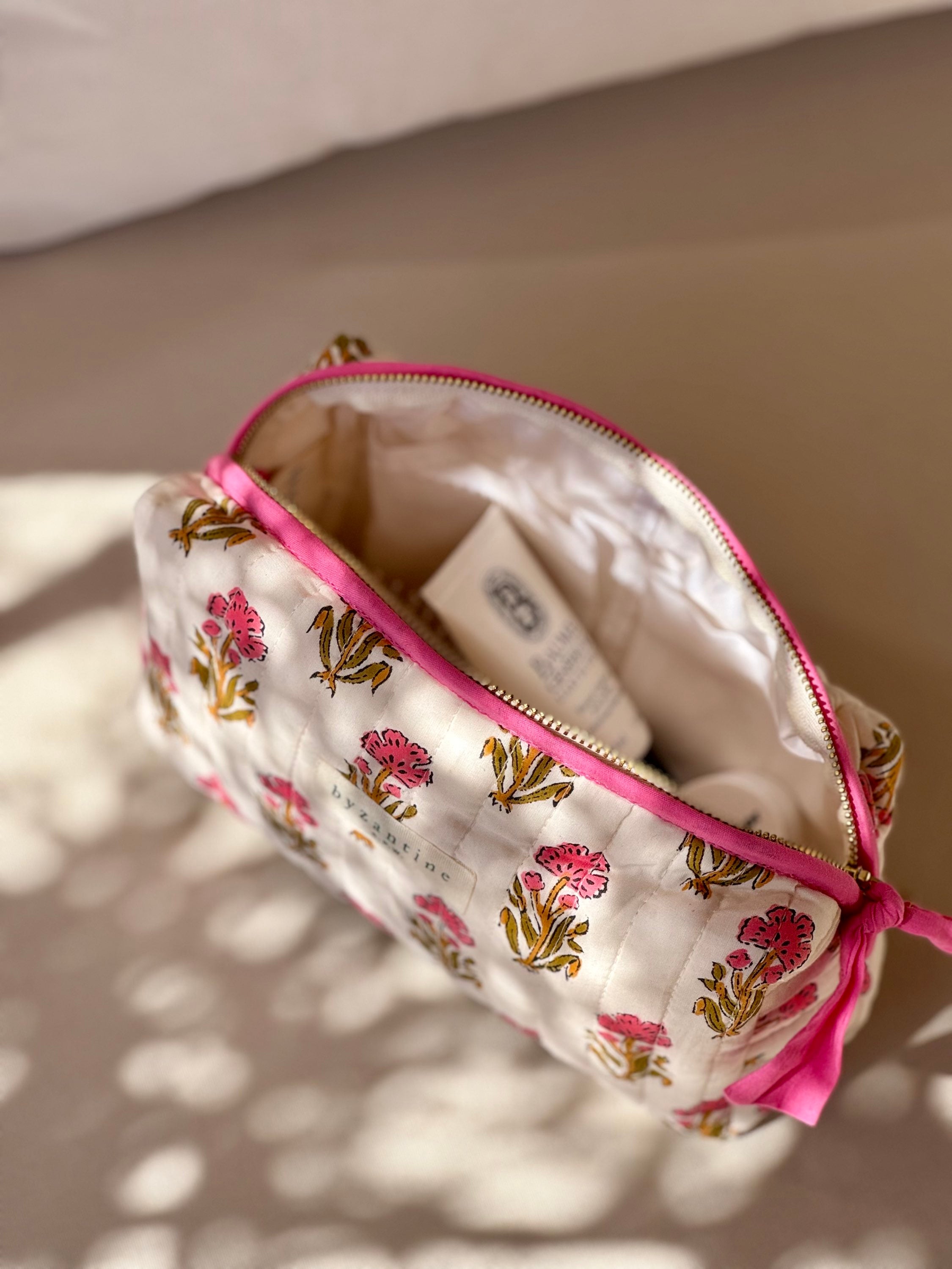 Petite trousse de toilette N°50 Rose ouverte sur un banc