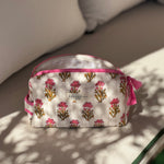 Petite trousse de toilette N°50 Rose, fleurs roses sur fond écru, sur un banc