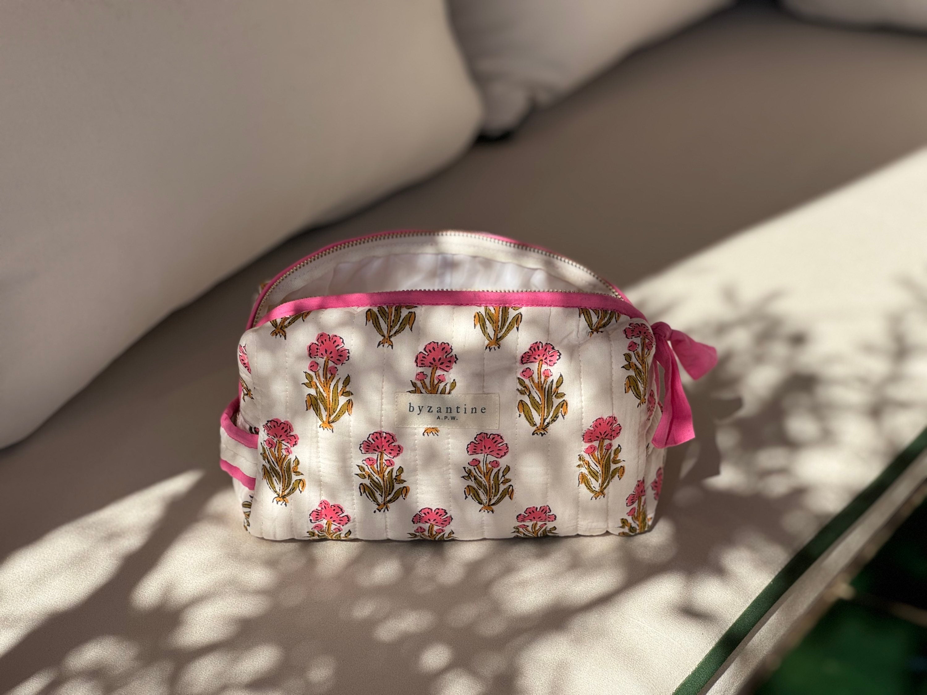 Petite trousse de toilette N°50 Rose, fleurs roses sur fond écru, sur un banc