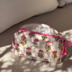 Petite trousse de toilette N°50 Rose posée sur un banc au soleil