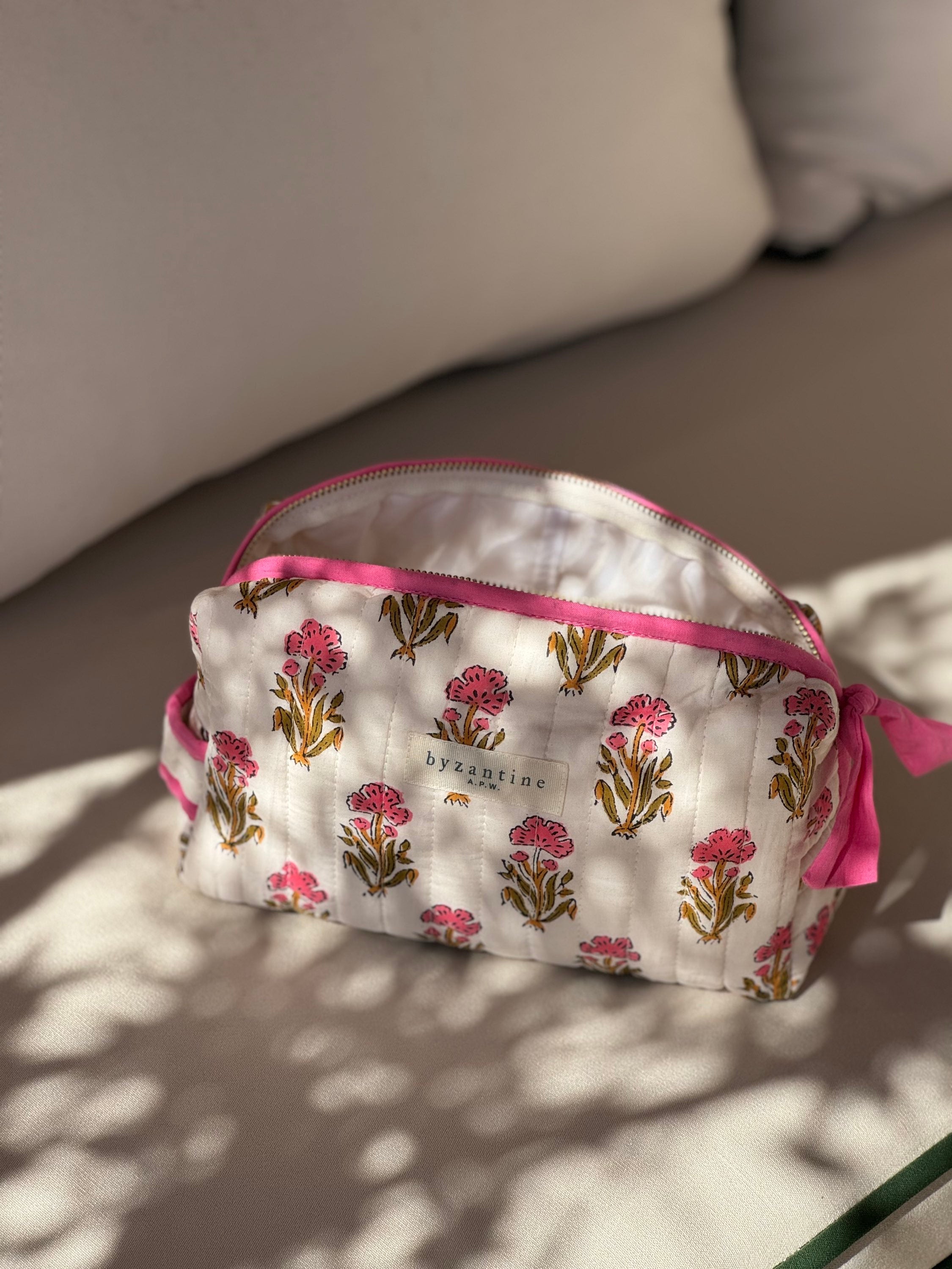 Petite trousse de toilette N°50 Rose posée sur un banc au soleil