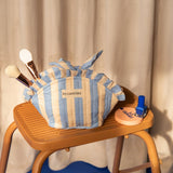 Petite trousse froufrou Pacha Bleu ciel nouée, avec pinceaux et vernis, sur un escabeau
